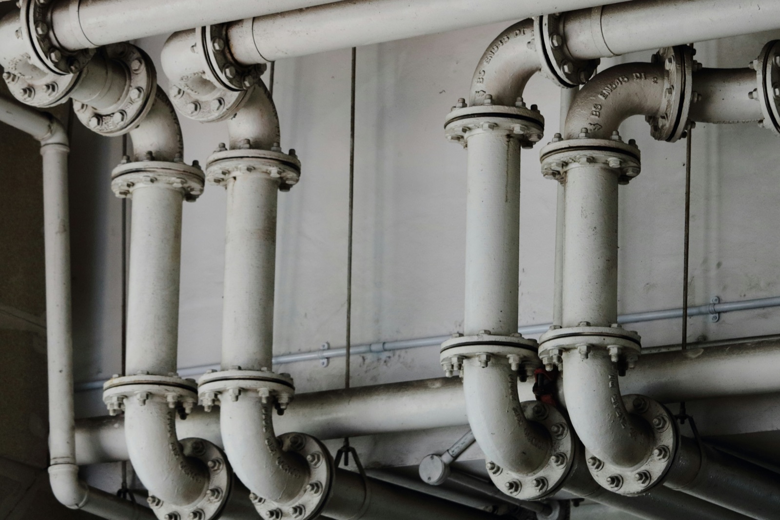 Grayscale metal pipes in industrial setting for Epo-Weld™ HSS high strength structural epoxy heat exchanger